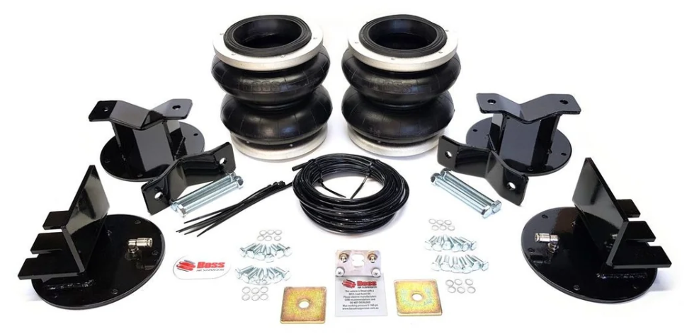 Complete air suspension kit laid out: four airbags, mounting brackets, hardware, and air lines ready for install.