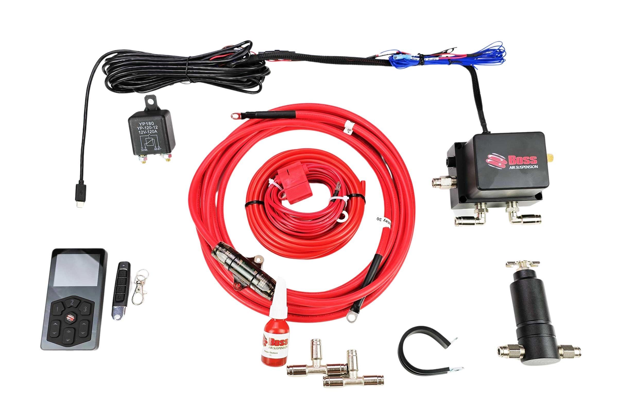 Automotive air suspension kit parts laid out: red air hoses, control module, remote, and fittings on a white background. contrasty hardware included.